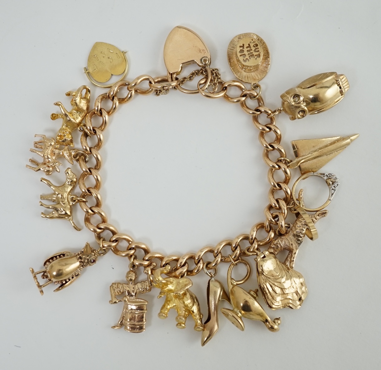 An early 20th century 15ct gold curb link charm bracelet